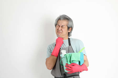 The senior Asian housekeeper standing on the white background.の写真素材