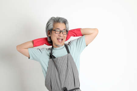 The senior Asian housekeeper standing on the white background.の写真素材