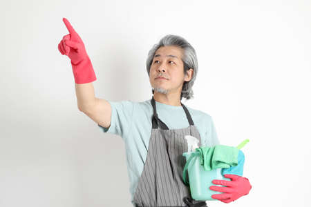 The senior Asian housekeeper standing on the white background.の写真素材