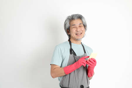 The senior Asian housekeeper standing on the white background.の写真素材
