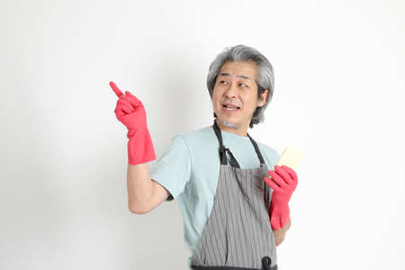 The senior Asian housekeeper standing on the white background.の写真素材