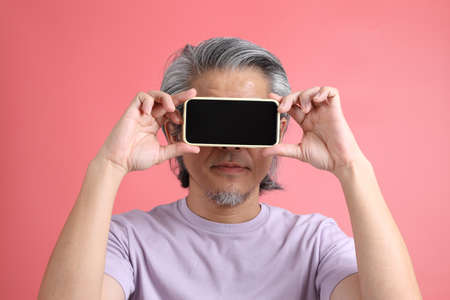 The senior Asian man portrait with no retouched skin in the pink background.の写真素材