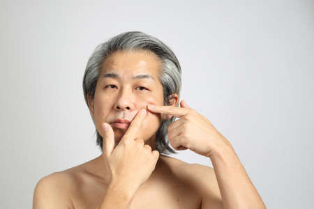The senior Asian man portrait with no retouched skin in the white background.の写真素材