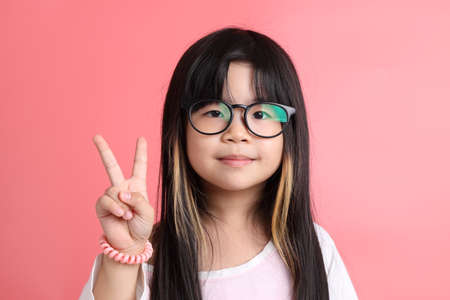 The young Asian girl portrait on the pink background.の写真素材