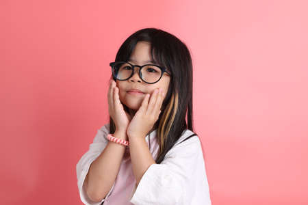 The young Asian girl portrait on the pink background.の写真素材
