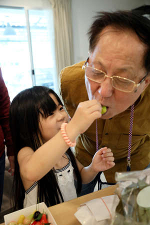 The young Asian girl sharing her desserts to her grandfather.の写真素材