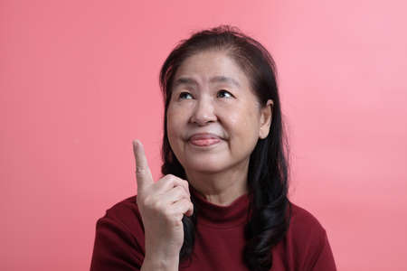 The senior Asian woman portrait with no retouched skin in the pink background.の写真素材
