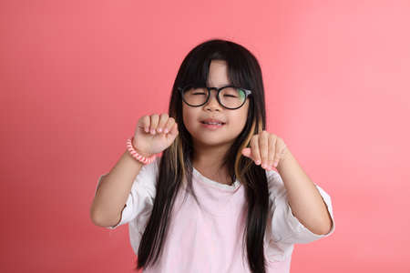 The young Asian girl portrait on the pink background.の写真素材