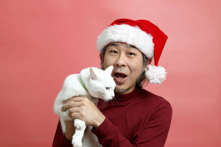 The Asian man portrait with santa claus hat on the pink background.の写真素材