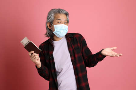 The senior Asian man portrait on the pink background.