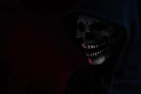 The skull mask with hood shirt in the dark background.の写真素材