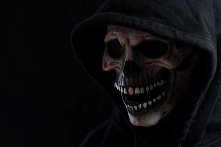 The skull mask with hood shirt in the dark background.