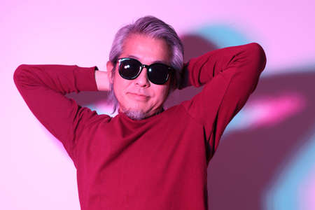 The cool senior Asian man in the gel color light photography.の写真素材