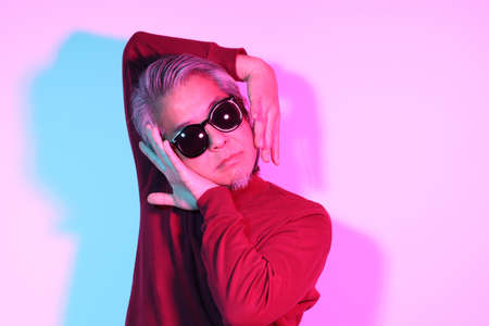 The cool senior Asian man in the gel color light photography.