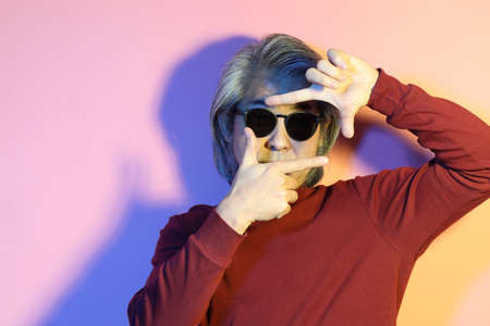 The cool senior Asian man in the gel color light photography.の写真素材