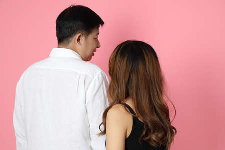 The Asian couple standing on the pink background.の写真素材