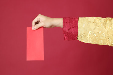 The Chinese man hand with tradion dressed on the red background.の写真素材