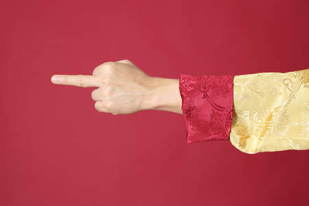 The Chinese man hand with tradion dressed on the red background.