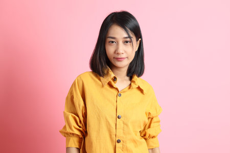 The mixed race woman standing on the paink background.の写真素材