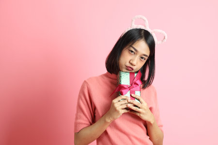 The mixed race girl portrait standing on the pink background.