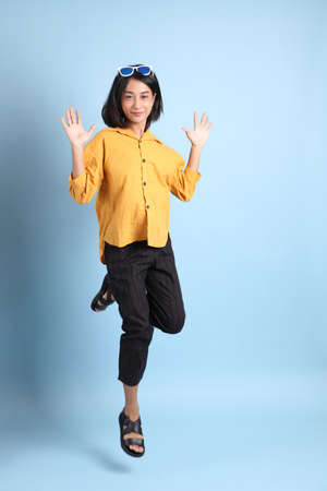 The mixed race girl portrait sitting on the blue background.