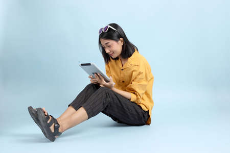 The mixed race girl portrait sitting on the blue background.の写真素材