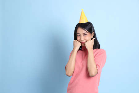 The young Asian woman wearing pink clothes standing on the blue background.の写真素材