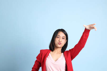The beautiful Asian woman standing on the blue background.の写真素材