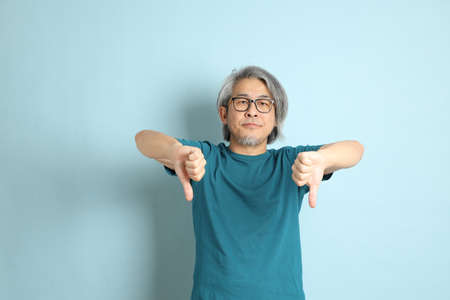 The senior Asian man on the blue background.