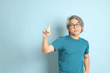 The senior Asian man on the blue background.の写真素材
