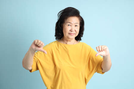 The senior Asian woman on the blue background.の写真素材