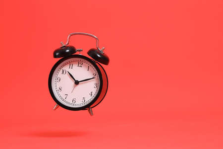 The isolated picture of clock floating on the orange background.の写真素材
