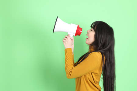 The cute young Asian girl with casual dressed standing on the green backgroundの写真素材
