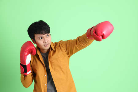 The young adult Asian man with smart casual clothes standing on the light green background.の写真素材