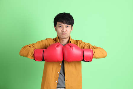 The young adult Asian man with smart casual clothes standing on the light green background.の写真素材