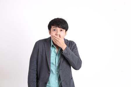The young adult businessman standing on the white background.の写真素材