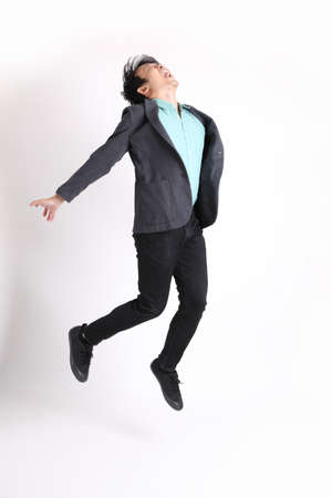 The young adult businessman standing on the white background.