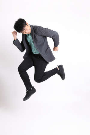 The young adult businessman standing on the white background.の写真素材