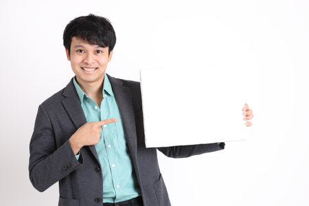The young adult businessman standing on the white background.の写真素材