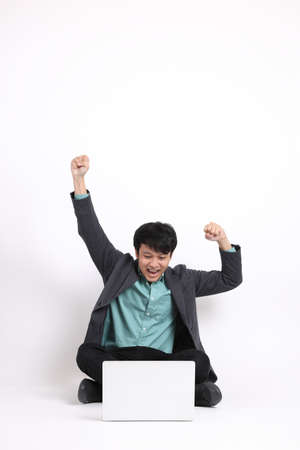 The young adult businessman sitting on the white background.の写真素材