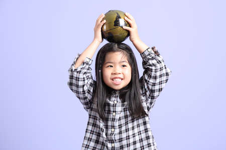 The young Asian gril standing on the purple background.の写真素材