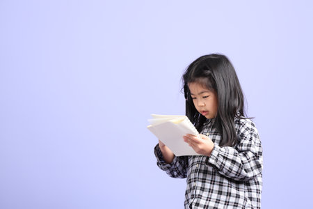 The young Asian gril standing on the purple background.の写真素材