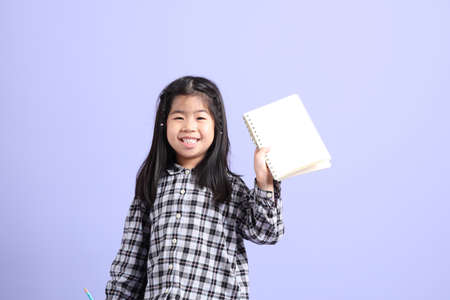 The young Asian gril standing on the purple background.の写真素材