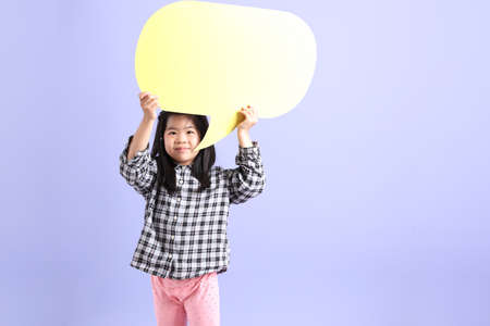 The young Asian gril standing on the purple background.