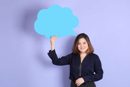 The chubby Asian woman standing on the purple background with the casual clothes.の写真素材