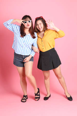 The Asian happy sibling standing on the pink background.の写真素材