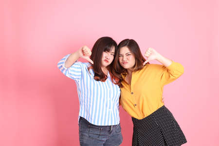 The Asian happy sibling standing on the pink background.の写真素材