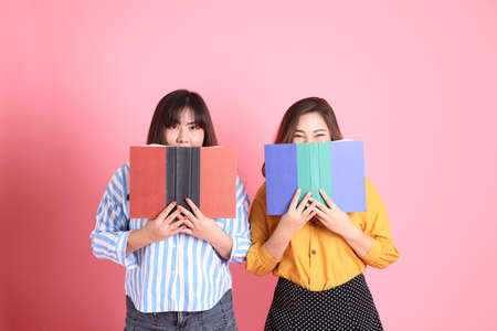 The Asian happy sibling standing on the pink background.の写真素材