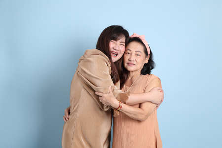 The happy Asian family standing on the blue background.の写真素材