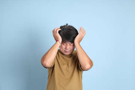 The senior Asian man with casual clothes standing on the blue background.の写真素材